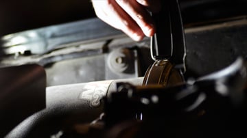 Automotive enthusiast DIYer releasing a valve during a maintenance project