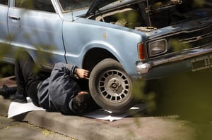 Autmotive DIYer performing maintenance under a truck