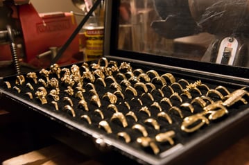 Display box full of gold rings created by jewelry maker using lost wax casting method