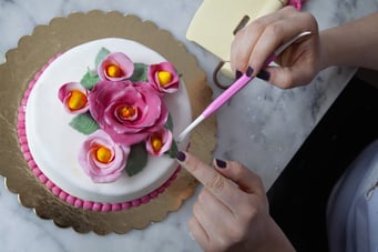 Pinterest-style cake decorating with flowers on a marble table