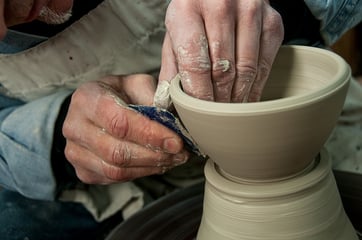 Ceramicist throwing a clay bowl on a pottery wheel