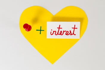 Yellow paper heart with a pin and interest