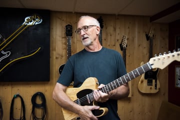 Modern luthier Dave Lackey holding his handmade electric guitar