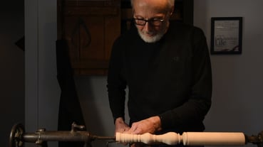 Master woodturner cutting a chair leg on a lathe