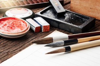 Calligraphy and hand lettering tools and ink arranged on a table