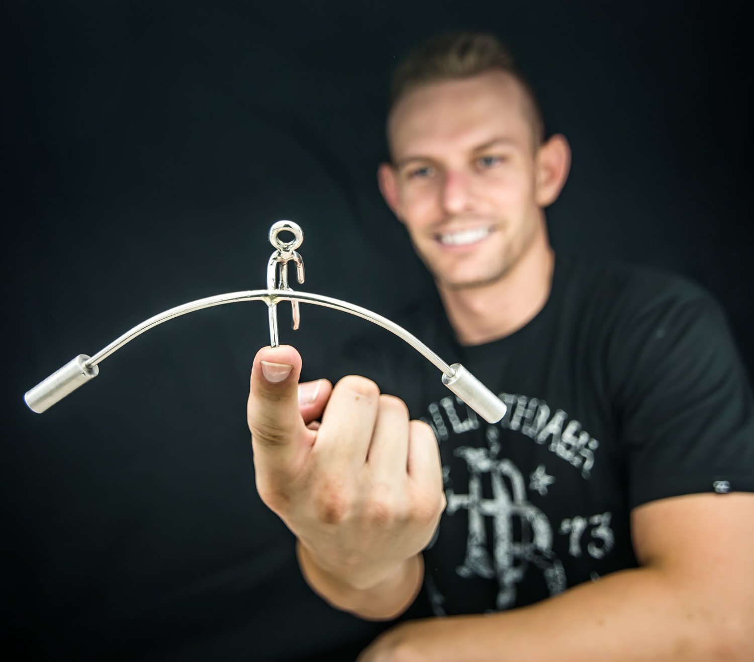 Kyle Auga of Kyle's Kinetics balances one of this metal sculptures on his finger